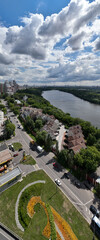 panoramic view of the cityscape with high-rise buildings, freeways and green parks on a sunny day taken from a drone