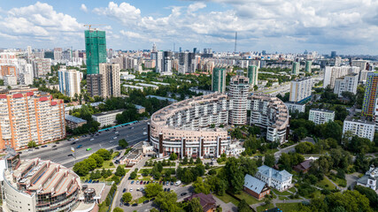 panoramic view of the cityscape with high-rise buildings, freeways and green parks on a sunny day taken from a drone