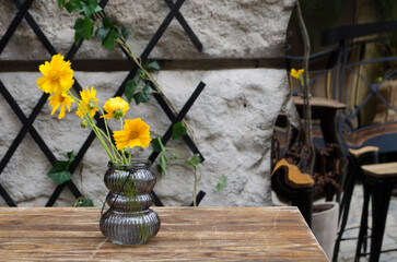 Yellow flowers in a vase on the background of the decor of the ancient city.