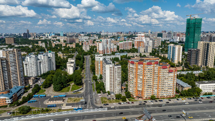 panoramic view of the cityscape with high-rise buildings, freeways and green parks on a sunny day taken from a drone