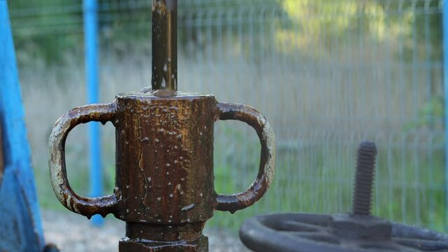 Eye level view of pumpjack polishing rod and stuffing box, crude oil overflows
