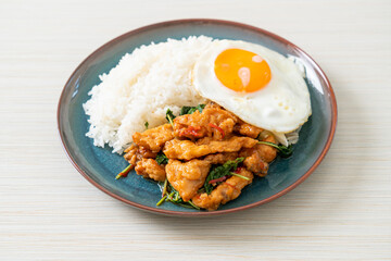 stir-fried fried fish with basil and fried egg topped on rice