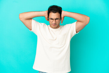 Fototapeta na wymiar Caucasian handsome man over isolated blue background frustrated and covering ears