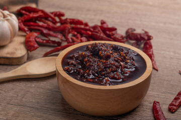 Thai spicy chili paste in a wooden cup (nampnikpao)