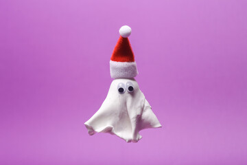 Merry christmas, halloween concept. Ghost with eyes in santa hat on purple background