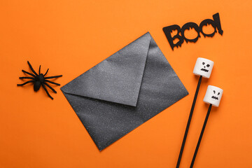 Halloween decor with envelope on orange background. Top view. flat lay