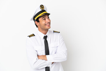 Airplane pilot over isolated white background looking up while smiling