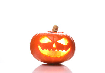 Scary smiling halloween jack lantern pumpkin head with burning candle isolated on white background with reflection