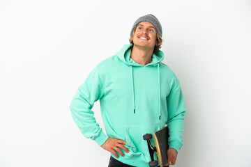 Young skater blonde man isolated on white background posing with arms at hip and smiling