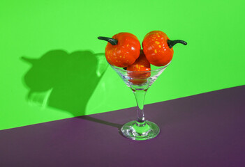 Halloween party. Halloween pumpkins with cocktail martini glass on green purple background. Minimal layout