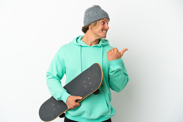 Young skater blonde man isolated on white background pointing to the side to present a product