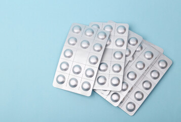 Metal blisters of pills on blue background