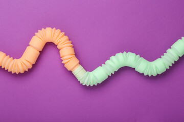 Antistretch pop tubes toy on purple background. Top view