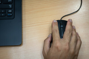Action of worker hand is using and clicking on notebook mouse, office working scene photo. Close-up...