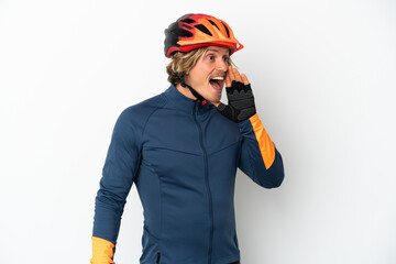 Young blonde cyclist man isolated on white background shouting with mouth wide open to the side