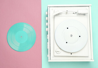 Turntable vinyl record player on pink blue background. Sound technology for DJ to mix and play music. White vinyl record. Minimalism. Flat lay. Top view