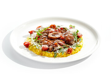 Traditional Italian dish - osso buco with risotto Milanese and cherry tomato and rucola. Ossobuco with saffron rice isolated on white background. Stewed meat on bone with yellow risotto.