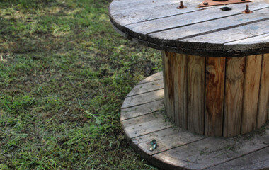 Naklejka premium an old wooden coil stands in the garden