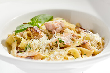 Traditional Italian lunch - pasta fettuccine with chicken and mushrooms with parmesan cheese. Creamy pasta with mushroom and chicken. Chicken and mushroom in cream sauce with homemade pasta.