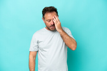Middle age caucasian man isolated on blue background with headache