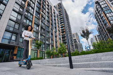 Young multiracial woman riding a scooter around the city