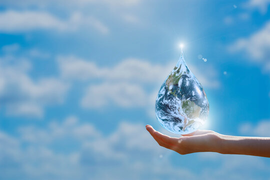 Globe or Earth in shape of water droplet on hand over blue sky background. Elements of this image furnished by NASA.