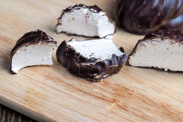 white creamy marshmallows in milk chocolate, close up