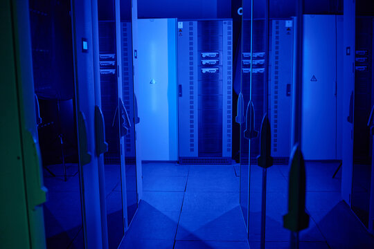 Shot of data center with multiple rows of fully operational server racks