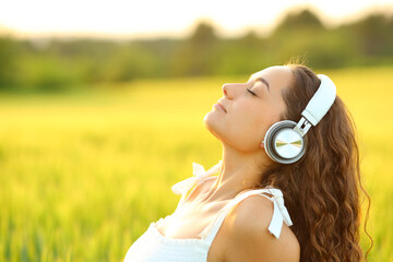 Woman meditating listening music with headphones - obrazy, fototapety, plakaty