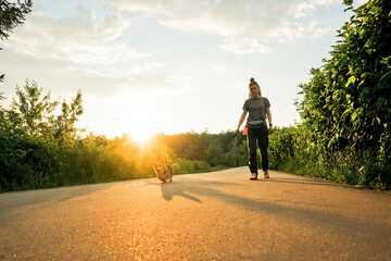 Obraz premium Woman with dreadlocks walk with dog corgi.