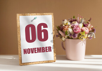 november 6. 6th day of month, calendar date.Bouquet of dead wood in pink mug on desktop.Cork board with calendar sheet on white-beige background. Concept of day of year, time planner, autumn month