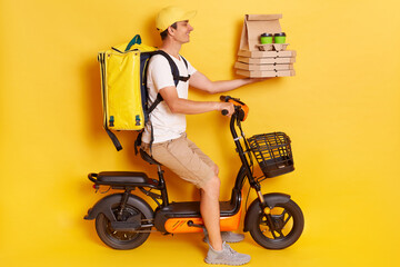 Profile portrait of courier man wearing cap and t-shirt driving electric bike motorbike handing...