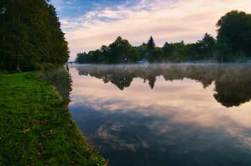 A sunrise at dawn, with fog on the river and warm light atmosphere. Landscape shot