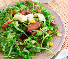 mixed salad of arugula and fresh vegetables with sauce