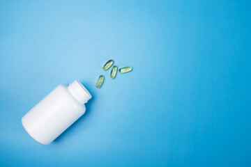 omega 3 capsules, fish oil, vitamin d on a blue medical background