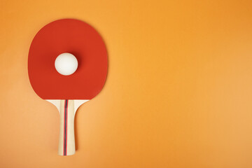 table tennis racket and ball on orange background, sport, copy space