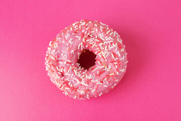 donut with pink icing and sprinkles, top view, sweets and confectionery, cake for breakfast, fat...