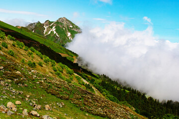 travel and tourism, alpine mountain landscape with green meadows and clouds