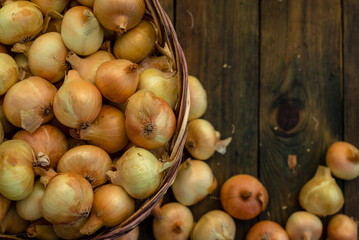 Fresh Red onion in basket on wooden table, top view, Organic food brown slices, still life rustic  raw cutting board outside wicker basket Bulb Food Ingredients local farmers market store