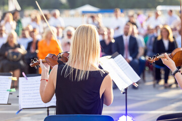 Classical music concert outdoors, blurred audience in the background