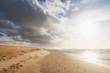 Clouds over sandy beach at sunset
