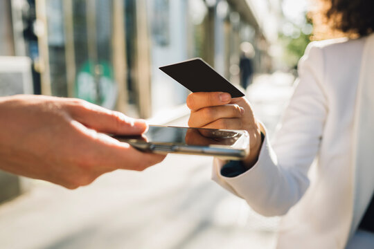 Businesswoman using credit card for payment at sidewalk cafe