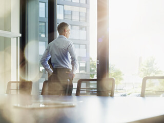 Businessman looking out through window in board room
