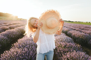 Woman playing with straw hat on lavender field