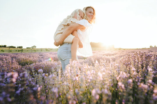 Happy mother giving piggyback ride to daughter