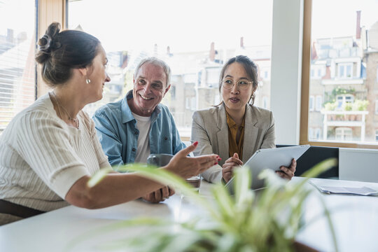Mature businesswoman with colleagues discussing work in office