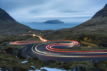 Faroe Islands, Streymoy, Vehicle light trails stretching along remote winding road