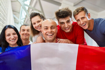 Happy sports fans with French Flag in stadium