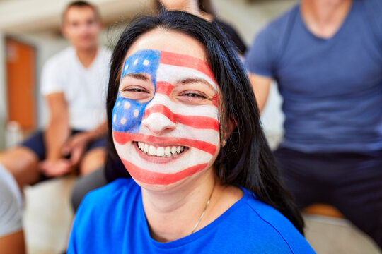Cheerful woman with American Flag painted on face