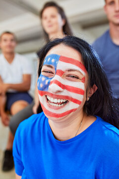 Happy woman with American flag painted on face